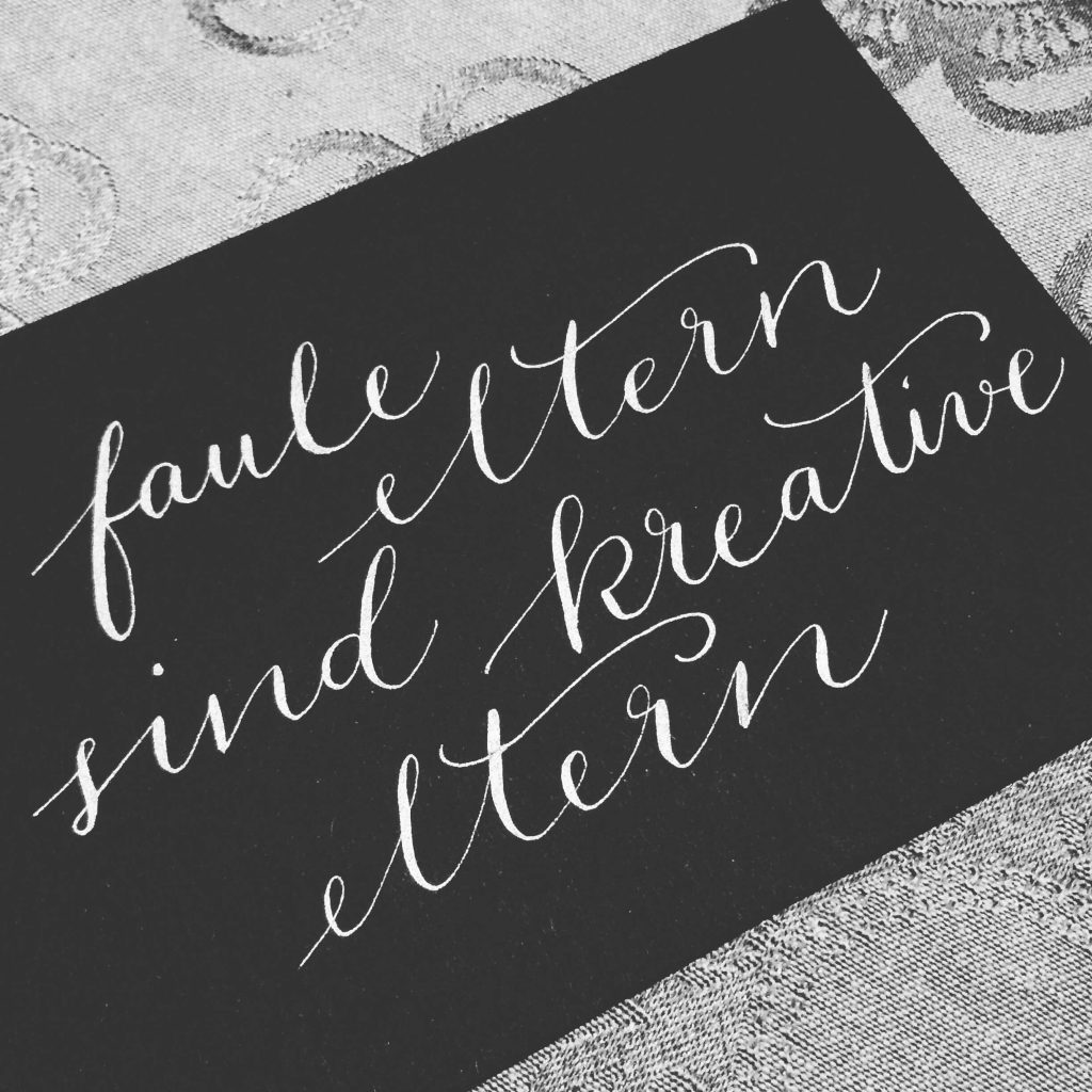 Kalligrafie mit weißer Tinte auf schwarzem Papier