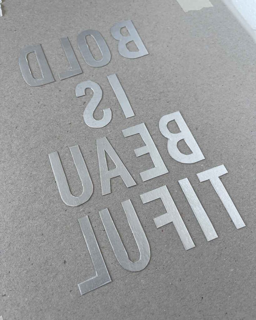 Collagrafie mit Schrift – Druck aus seitenverkehrtem Milchkarton-Motiv